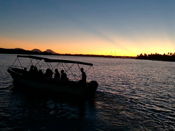 Silueta de la lancha con pasajeros navegando al atardecer