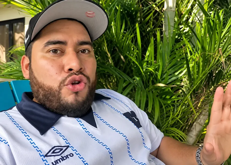Vlogger con gorra hablando frente a la cámara junto a la piscina