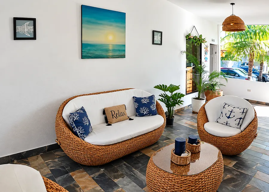 Sala lounge del hotel con muebles de mimbre y cojines náuticos